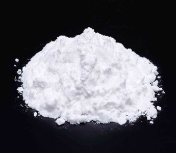 Magnesiumbisglycinat, weißes Pulver auf schwarzer Fläche